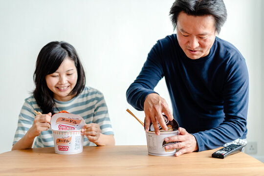 Couple enjoying instant noodles together.