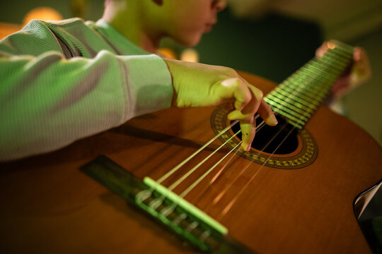 Boy learning playing classical guitar at home