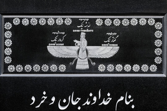 Close-up of a black marble gravestone featuring the Faravahar symbol and the mottos: Good Thoughts, Good Words, Good Deeds in English