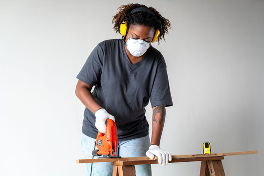 Focused carpenter using saw.