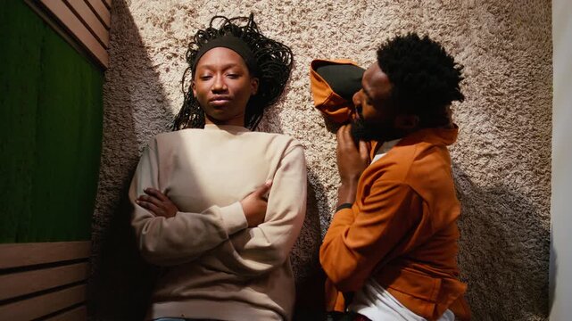 Top down view of black girl with trust issues ignoring her man, being angry and offended after heated argument. Guilty frustrated boyfriend asking for forgiveness, infidelity accusation and tension.