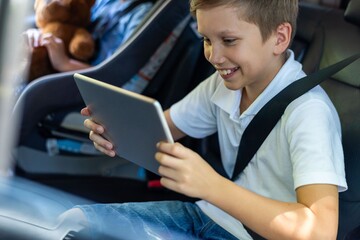 Naklejka premium Child enjoying tablet during travel