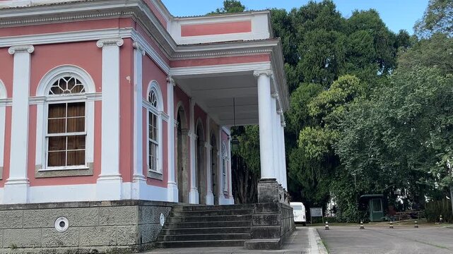 Elegant heritage Aarchitecture with female visitor exploring outdoors Petropolis Brazil, look down camera medium shot