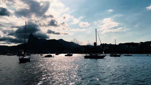 Scenic waterfront with sailboats and mountain view toward Corcovado in Rio de Janeiro Brazil, panning left