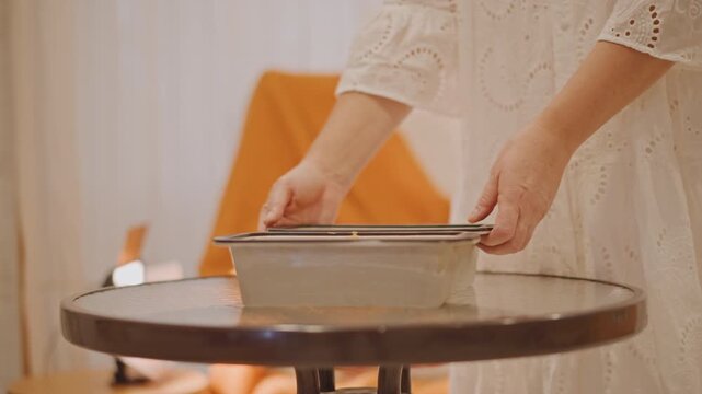 White woman carries pumpkin pie pan across warm kitchen table then places pan into oven during cozy autumn baking scene, lace dress, orange throw on chair, kettle on stove, gentle morning light,