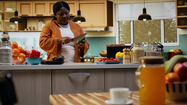 Food blogger filming step by step avocado cutting tutorial indoors, woman content creator demonstrating meal prep and recipe preparation on a cutting board. Rich in proteins avocado on toast.