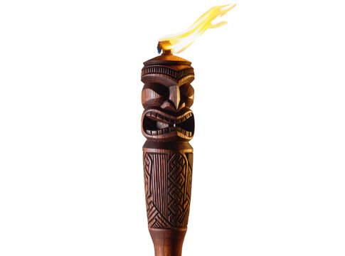 Isolated traditional carved wooden tiki torch with bright burning flame, exotic tropical party decoration