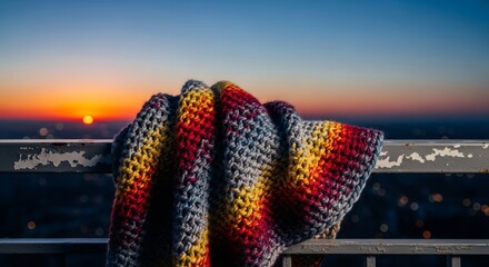 Naklejka premium A thick knit covering rests against a cold railing on a high terrace during twilight, capturing a mood of deep isolation and quiet sorrow, loneliness, sadness, moody