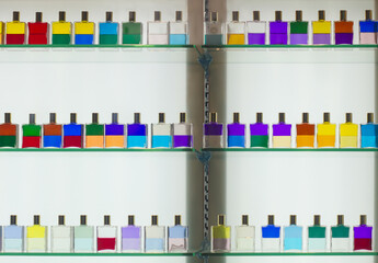 Fototapeta premium Colorful dual-layered liquid bottles on glass display shelves