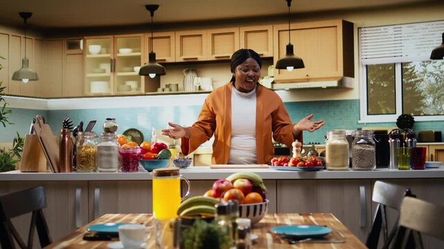 Filming cooking tutorial, food vlogger, online content in the kitchen, recording a video with meal prep and fresh ingredients at the counter. Black woman home chef explaining step by step.