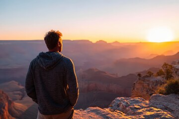Obraz premium Hiker Overlooking Grand Canyon at Sunset