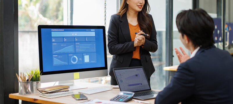 Business Professionals Analyzing Financial Dashboard in Modern Office