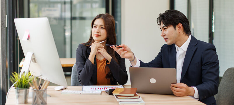 Two asian business people in meeting discussing plans together investment data report Financial and tax systems concept.
