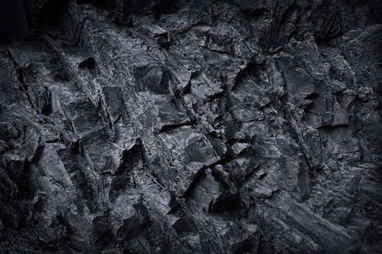 Black dark graphite gray rock stone texture background. Mountain surface. Close-up. Grunge rough solid hard. Design.