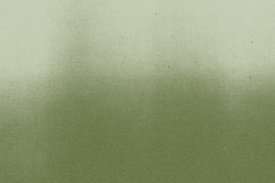Grunge background with a textured, faded green background. The green color gives a vintage, distressed look to the background. Green textured paper background with copy space.