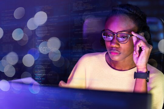 Focused woman coding at night image