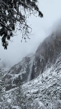 snowstorm and foggy morning over Yosemite valley and Bridalveil Falls in the distance on a winter day in Yosemite National Park, California