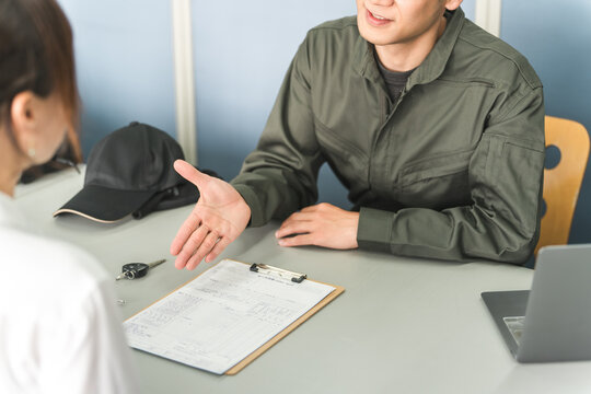 A male mechanic and a female customer are explaining, quoting, and proposing solutions at the reception desk of an auto repair shop.