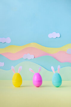 Happy Easter colorful eggs with bunny ears in pastel studio background spring holiday decoration.