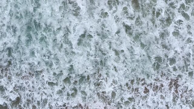 Ocean waves rolling to shore. Sea water moving forward. Ocean surf breaking on sand. Sea waves forming white foam. Ocean water rushing to beach. Sea surf in motion.