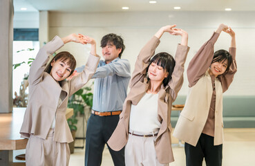 Businessmen and businesswomen stretching in the office