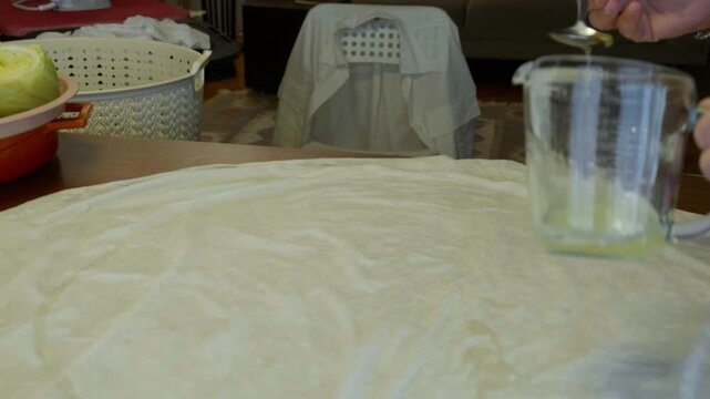 Close Up of Preparing Traditional Phyllo Dough with Oil and Water Mixture