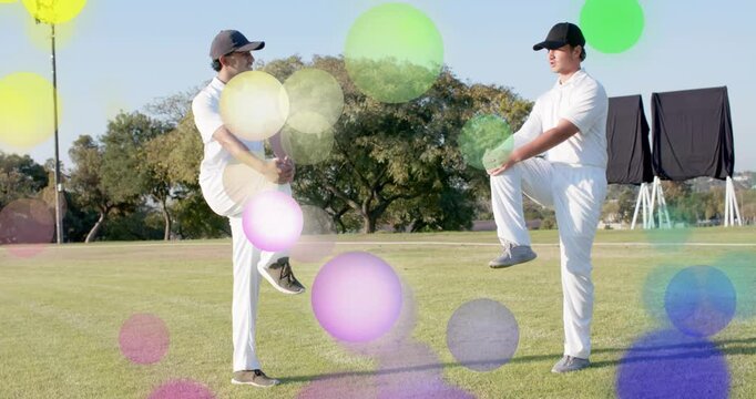 On cue two men performing in-sync one-leg sport warmup on field bright bubbles drifting across them