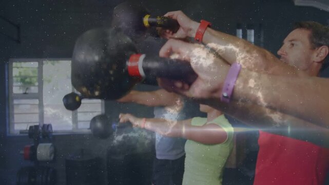 Fitness class starting kettlebell swings on cue in gym, nebula overlay showing kettlebells bands