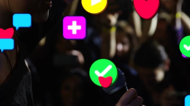 Camera cutting causing icons, singer singing into mic at dark venue, off-shoulder, phones for fans