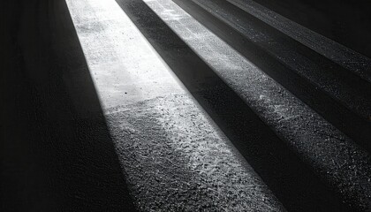 Obraz premium Ciemne, geometryczne cienie i smugi światła padające na chropowatą, betonową posadzkę wewnątrz.