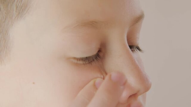teenage boy applying acne cream, Teen boy focused on facial skincare, highlighting self-image issues and teenage skin concerns