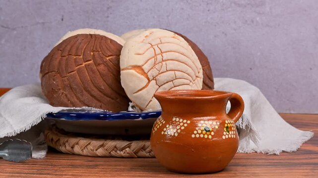 Conchas, Mexican bakery still life with traditional clay cup and sweet buns