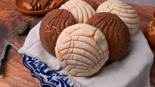 Variety of vanilla and chocolate conchas on a cloth napkin, traditional Mexican bread