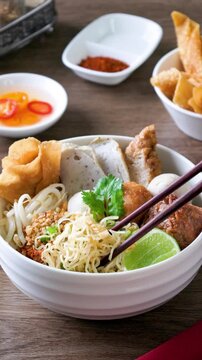 dry Chinese yellow noodles with bean sprout topping pork meatball 