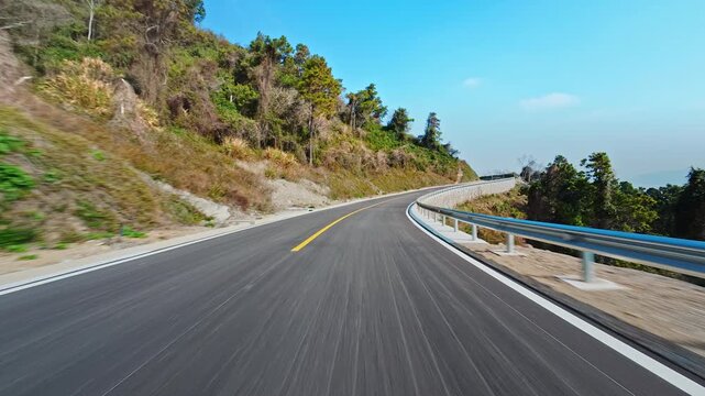 POV driving shot on a winding mountain road during a scenic road trip in summer