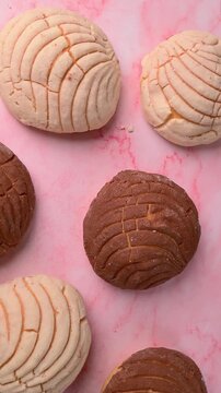 Mexican food, top view of traditional Mexican conchas on a pink marble surface
