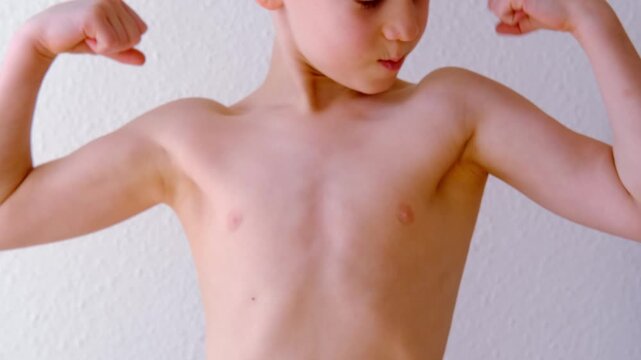 strong boy with naked torso, child 8-10 years old, performs physical exercises, trains strength of arm muscles, concept of demonstrating strength, reliability, sports for children