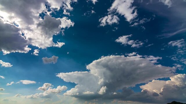 Central cloud breaking from instability, opening blue gaps and lit edges over horizon for weather