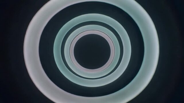 Concentric rings on play, pulsing and rotating, showing dark core and thin gaps for motion design