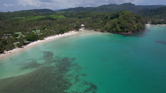 White Sand Beach Khlong Hin With Tropical Resorts And Palm Trees On Koh Kood Island, Thailand. aerial sideways shot