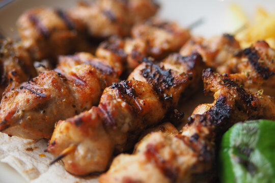 Grilled chicken kebabs served on a plate with vegetables