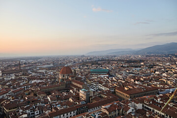 Obraz premium Panoramic view over a historic European city with dense rooftops at sunset