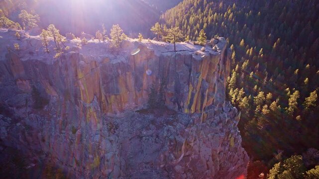 Cinematic drone footage of craggy rock formations with scattered trees in New Mexico desert
