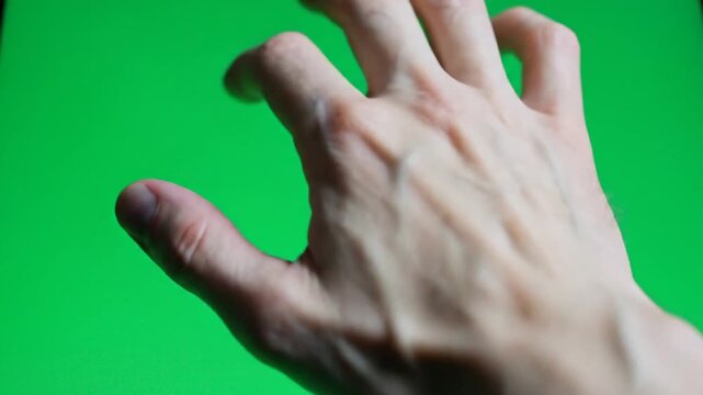 Close-up view of a human hand with fingers slightly curled against a vibrant green screen background, ready for digital compositing.