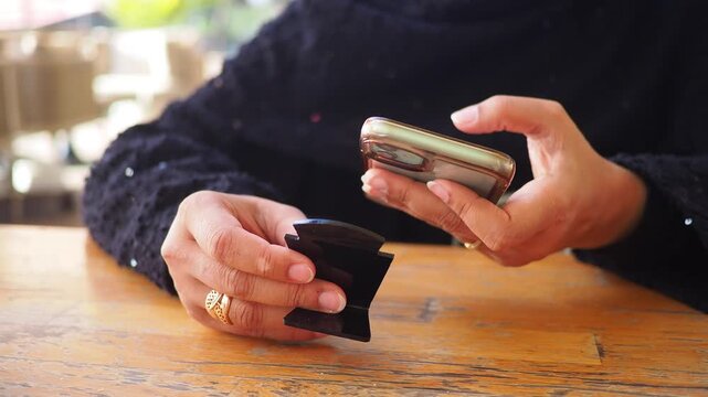 Woman uses phone to scan the QR code to find the menu at a cafe 