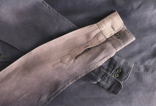 Close-up navy blue linen shirt, showcasing authentic sun-faded texture. This image embodies the slow fashion movement, the visible fading color on the sleeve represents a sustainable lifestyle.