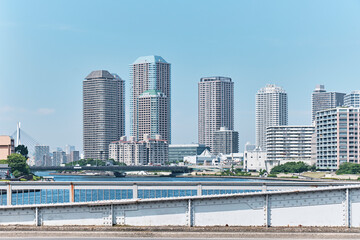 Naklejka premium Riverside skyline of modern high rise towers along calm urban waterfront