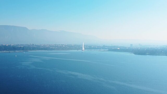 Aerial: Rade of Geneva during the day with water fountain in Geneva, Switzerland, dolly out drone shot