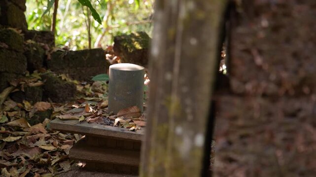 Ruins of ancient Shivling in old Hindu temple surrounded by dense forest, showcasing broken stone structure and spiritual heritage in natural jungle setting, India.