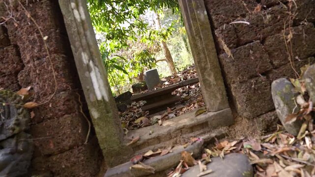 Ruins of ancient Shivling in old Hindu temple surrounded by dense forest, showcasing broken stone structure and spiritual heritage in natural jungle setting, India.
